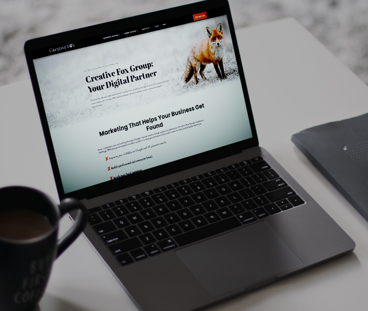 Laptop with Creative Fox Group website on it.